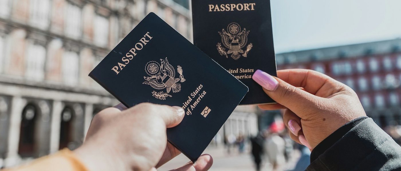 Person comparing passports and visa documents for PTE Academic vs PTE Core decision